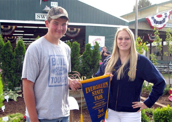 Cedarcrest FFA students Willy Wilen and Nicole Pearson hold their third-place banner for their garden design in the Evergreen State Fair's landscape competition.