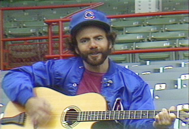 Steve Goodman plays “A Dying Cub Fan’s Last Request” at Wrigley Field in 1981. The Cub anthem will be played at an Aug. 5 North Bend benefit show. Below