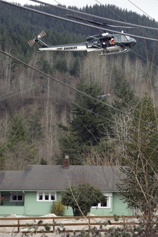 A King County rescue helicopter evacuates Fall City residents cut off by rushing water Thursday afternoon