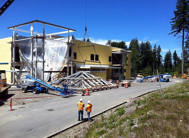 Workers with Absher Construction lift the tower cap of the future Snoqualmie Valley Hospital into place June 30. The cap covers the front entrance