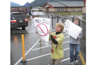 Cascade View fifth graders and Green Team members Jimmy Jacobson and Max Puff remind drivers to turn off their engines while waiting to pick up students. The no-idling initiative is one of the school’s many earth-friendly programs.