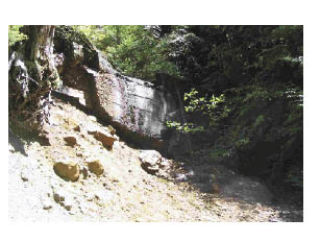 Waste rock lays near a foundation wall at the Rainy Mine and Mill near North Bend. The U.S. Forest Service plans to clean up arsenic-laden waste at the site.