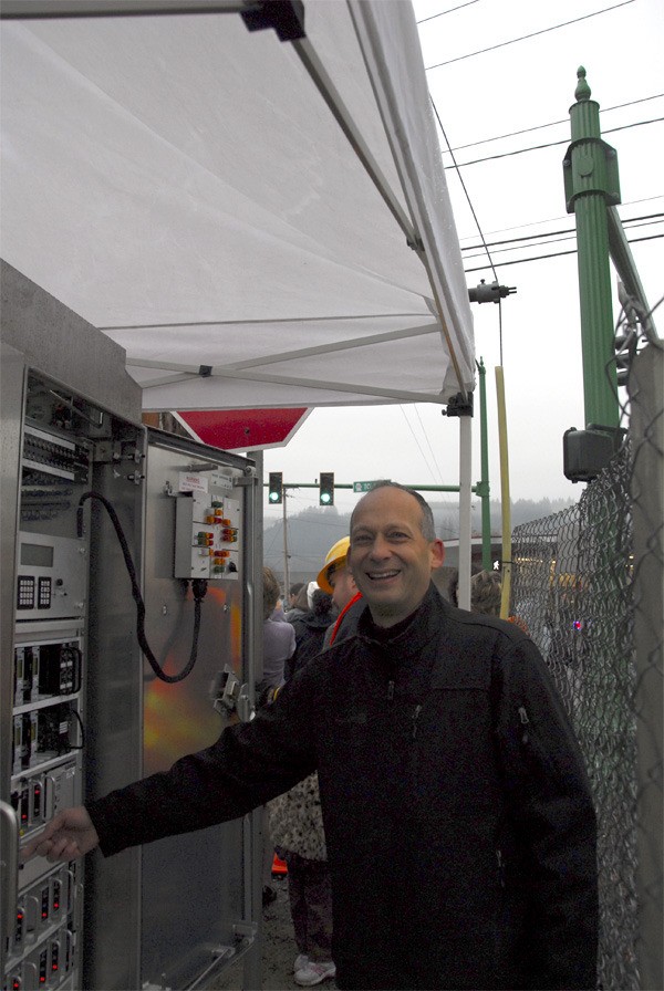 Carnation City Councilman Stuart Lisk grins as he flips the switch to light up the city's first-ever traffic signal