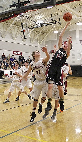 Right: Senior forward Chase Cardon goes up for a basket in the Cedarcrest High School match against Granite Falls Feb. 6.