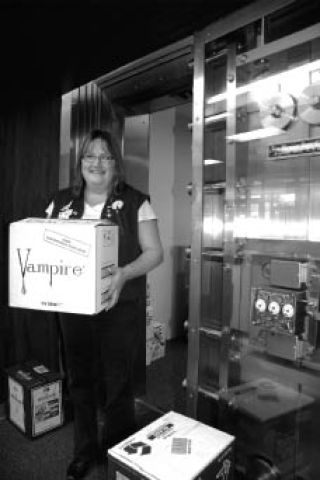 Snoqualmie state liquor store manager Deanna Riley carries a case of Halloween-themed bottles from the storage room