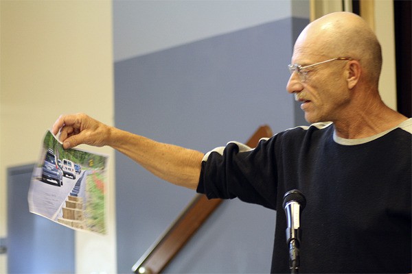 Duvall resident Rick Amish holds up a photo of narrow roadway at Stillwater during a September 30 meeting of Voters for a Safer 203. Amish pointed to an extra six feet of road embankment that