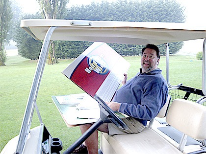 Rotary member Duncan Wilson sets up the hole-in-one sign for the annual Rotary golf tournament.