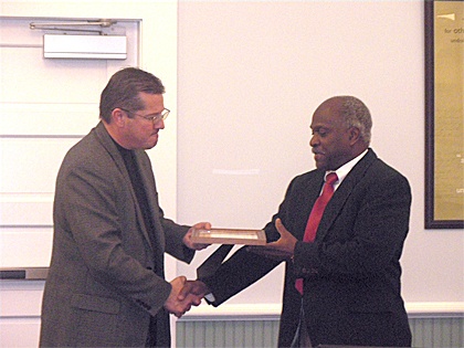 Superintendent Joel Aune presents Rudy Edwards a certificate for his dedication