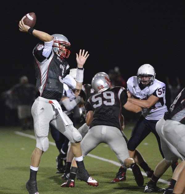 Mount Si quarterback Nick Mitchell winds up for a pass as Blake Herman