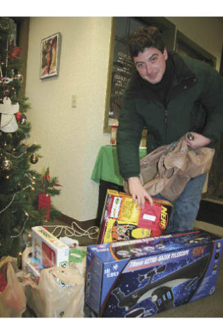 Seth Hoedl of North Bend places a toy under the Giving Tree at Sterling Savings in North Bend on Wednesday
