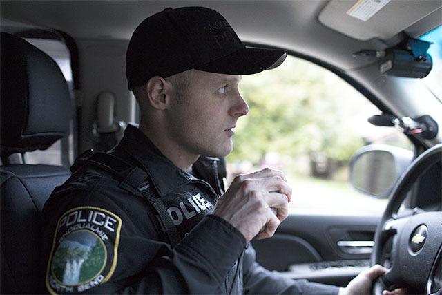 Snoqualmie Police Officer Grant Boere talks on the radio as he patrols North Bend on a Friday evening in February. This week marks the one-year anniversary of the department’s police service contract with North Bend.