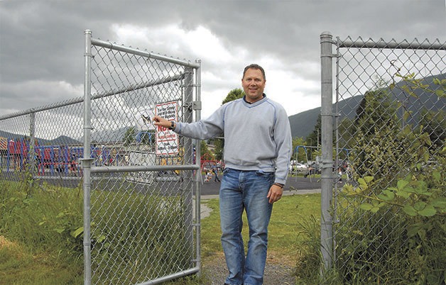 North Bend Elementary Principal Jim Frasier opens the gate from Snoqualmie Valley Trail to his school’s playground. The grounds at North Bend Elementary are at the center of a debate over whether security fences are needed.