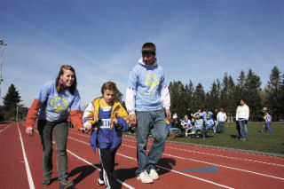 Mount Si High School students Amanda Orcutt and A.J. Leland cheer on Special Olympian Brandon Maji