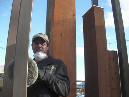 Kirk Derby buffs the new bronze finish on North Bend’s new gateway sculpture at Bendigo Boulevard.