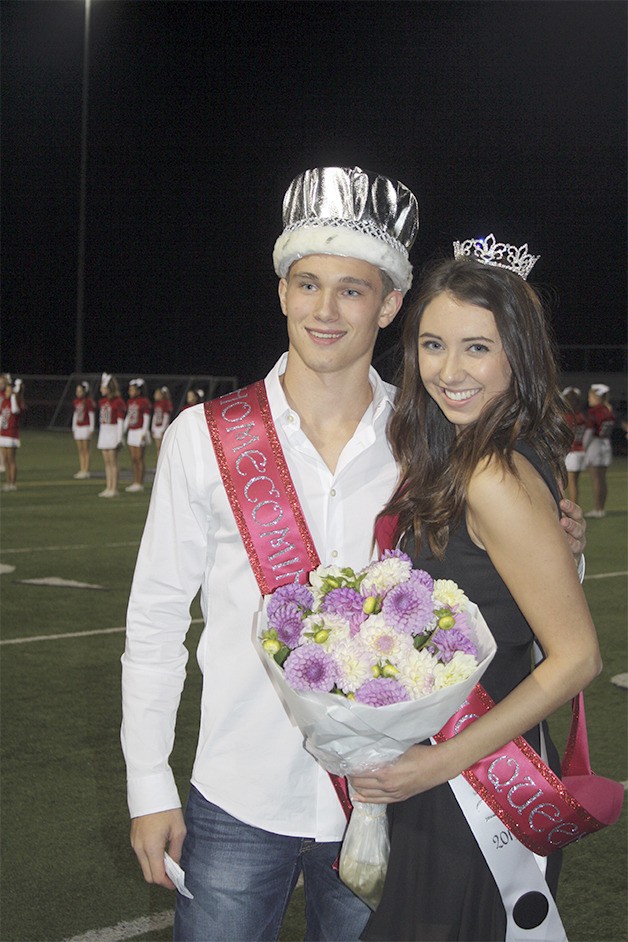 David Butler and Sami Kieffer walk off the Mount Si football field with crowns and a regal bouquet
