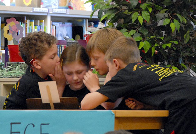 Fall City Elementary team captain Chloe Barber is swarmed by teammates whispering the answer to a question.