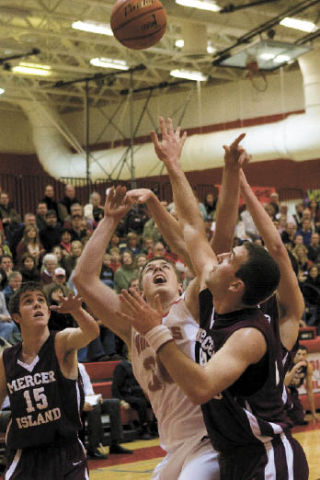 Lucas Zupan battles for the ball against a pair of Mercer Island defenders during last Thursday’s game. Mount Si won in overtime 64-62.