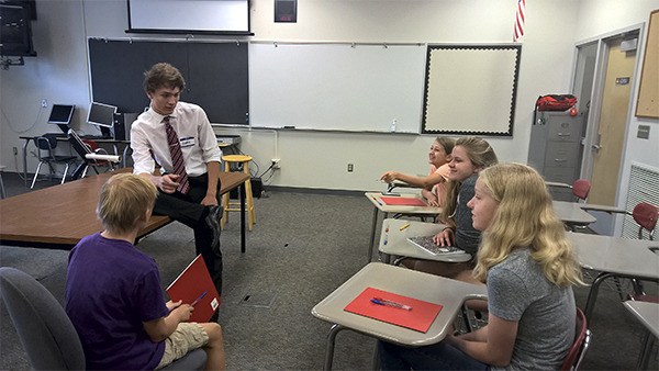 Ruary Thompson explains debate to interested students during a speech and debate camp held this summer.