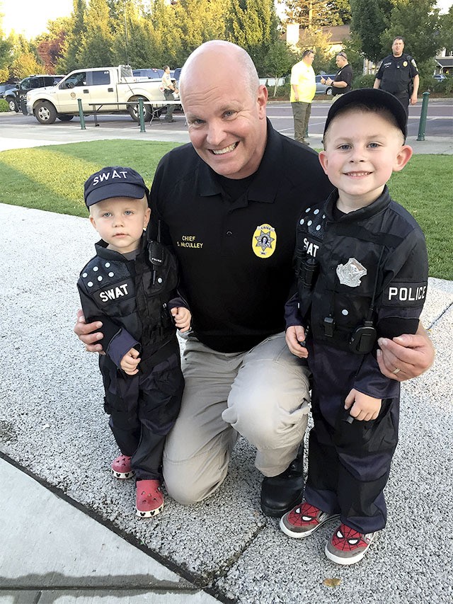 Police Chief Steve McCulley grins for a photo with two junior officers at the department's fourth annual National Night Out event