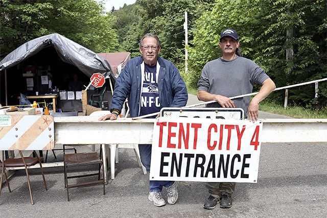 Camp advisors Sam Roberson and Perry Debell pose outside of the entrance to the Puget Sound area’s newest homeless encampment