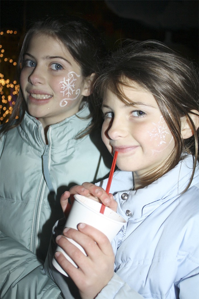 Two sisters sip cocoa at the Fall City Art Park during a past year's holiday festivities. Christmas celebrations return to downtown Fall City this Saturday.