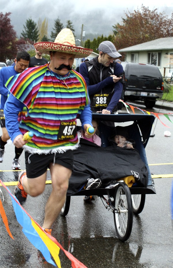 Runners—costumed or otherwise—move through the gate in the Cinco de Mayo half-marathon