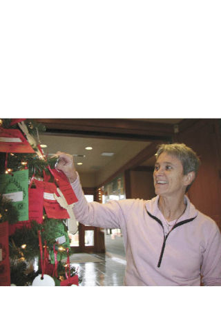 Debby Peterman of North Bend hangs ornaments on the Giving Tree at the North Bend Library