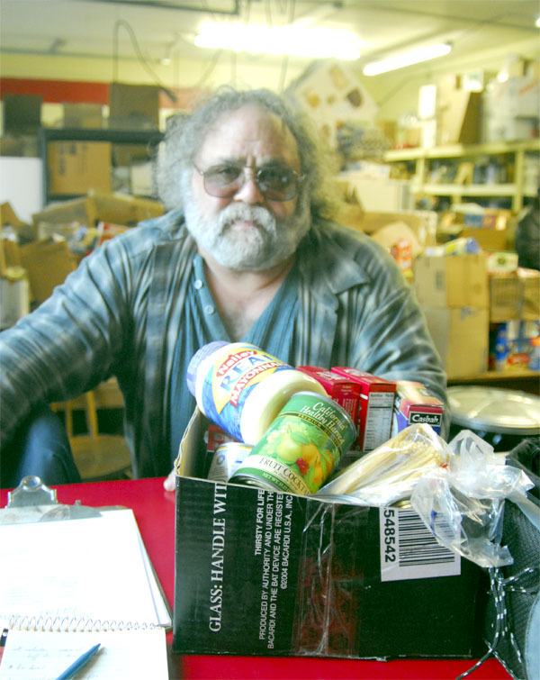 Snoqualmie Tribe Food Bank Manager Fred Vosk readies a box of basic food that all clients receive. Anyone may “shop” the rest of the facility for fresh produce and other needed items. The Carnation food bank is among Valley non-profits that have seen increased need this season.