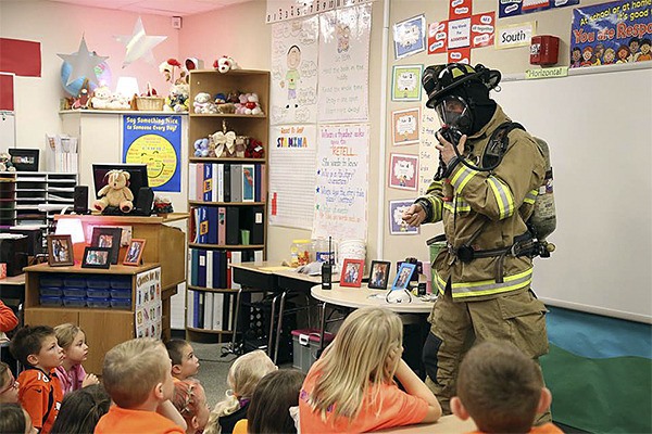 A Snoqualmie firefighter shows Snoqualmie Elementary School students how his mask works.
