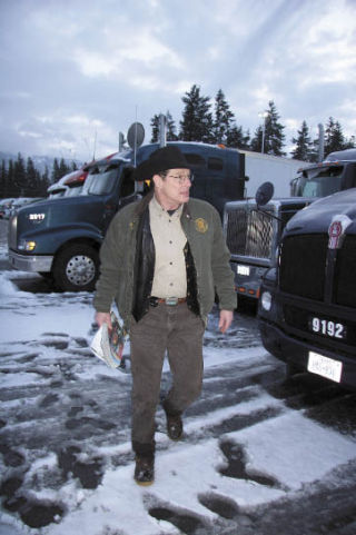 Tom Kemp strides across a snow-covered parking strip at Truck Town