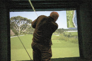 Fritz Ribary takes a swing on a video golf simulator at the Snoqualmie Ridge TPC