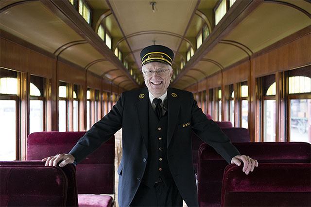 Museum board of trustees president Dennis Snook welcomes visitors aboard the Northwest Railway Museum train during a visit by officials from the Sound Cities Association in February.