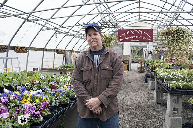 The Nursery at Mount Si founder Nels Melgaard stands inside of his greenhouse among a plethora of perennials.