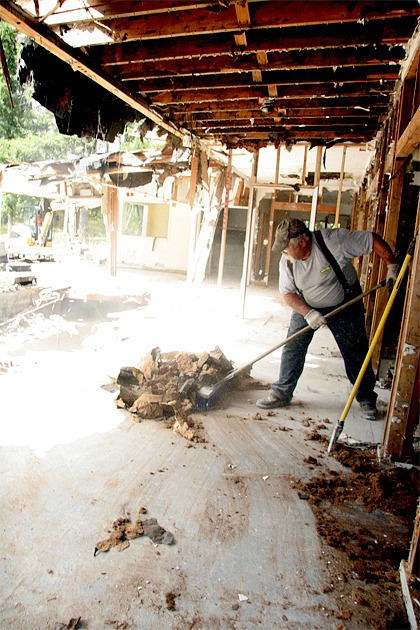 Chuck Hinzman sweeps up debris at the former Nelems Memorial Hospital building in Snoqualmie. The Snoqualmie Tribe demolished the site to make way for elder housing.