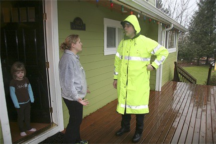 A Snoqualmie police officer checks in with a downtown family a few hours prior to the arrival of floodwaters in January 2009. Snoqualmie emergency responders give locals notice and urge residents to evacuate when necessary.