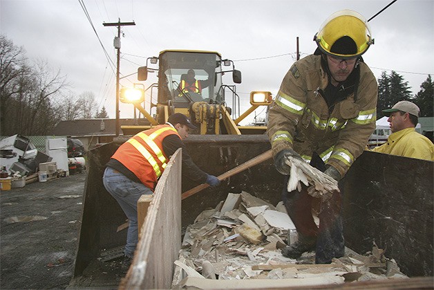 Workers dump debris from flooded homes during cleanup of the 2009 flood in Snoqualmie. Flood insurance can help homeowners recover from devastating floods.