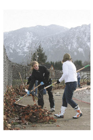Mount Si students Tabby Rollins and Heidi DeHart clean up flood debris at the high school entrance on Friday morning. They were among about 100 volunteer who helped get Mount Si High School back in shape.