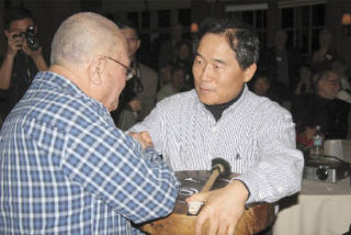 Native American elder Ron Stetler presents a drum to Ju Hong Hwang