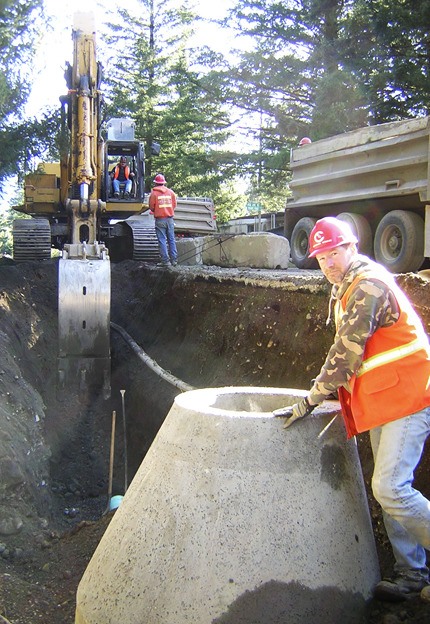 Northwest Cascade employee Jim Carter of Duvall keeps his eye on a co-worker down a manhole during sewer construction on 140th Avenue in North Bend. Major sewer installation continues throughout 2010 in North Bend’s Tanner annex.