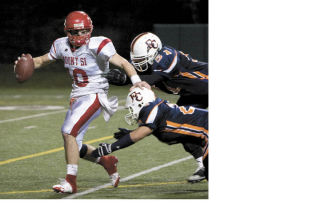 Mount Si quarterback Tyson Riley attempts to get away from two approaching Eastside Catholic defenders during last Friday’s playoff game against the Crusaders in Seattle.