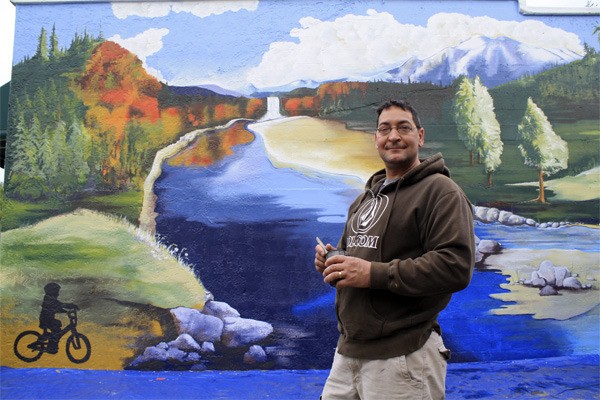 Lead artist Brian Major puts the finishing touches to the community mural Thursday