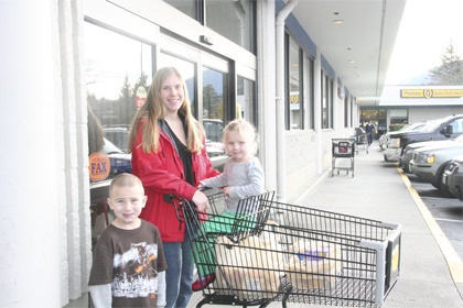 North Bend resident Candace Zimmerman taker her children Kayen and Aspen to North Bend’s QFC to do some last minute Thanksgiving shopping. To stay sane during the holiday season