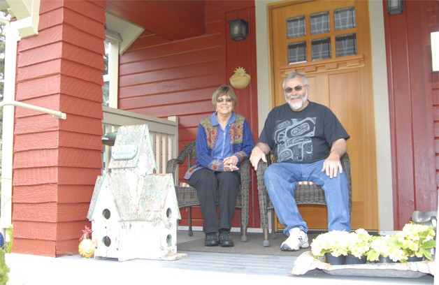 Kris and Dick Kirby relax on the porch of the house that they recently restored to its original 1914 look. Dick lived in the house as a teenager