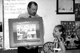 State transportation official Randy Giles presents Jennifer Corgiat with a framed copy of her drawing