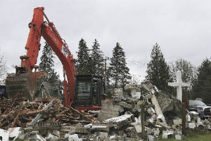 Demolition contractor Nuprecon brings down the 80-year-old structure of St. Clare of Assisi Episcopal Church on Monday