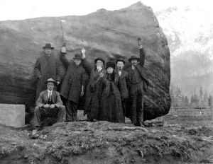 North Bend city founder William H. Taylor and several North Bend pioneers gather in front of a large log in this photo