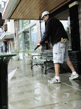 Mike Sellers washes the sidewalk in front of Twede’s Cafe