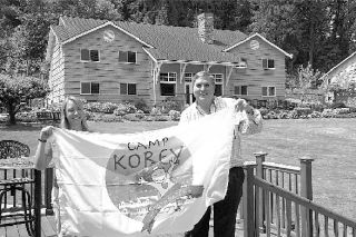 Camp Korey Director Hillary Carey and founder Tim Rose show off the camp’s flag. As a fund-raising effort