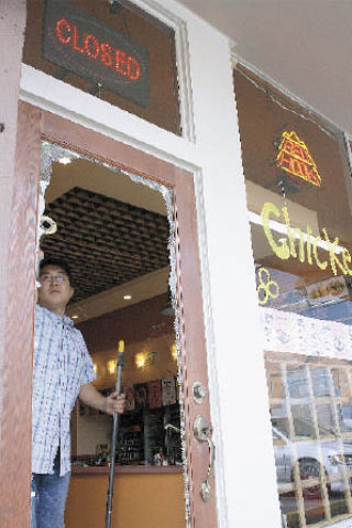 Soon Kook Kwon knocks glass shards from Mori Bistro’s front door on Thursday