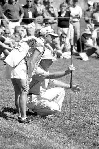 2008 Boeing Classic tournament winner Tom Kite looks at the line of his putt on the 18th green with his caddy